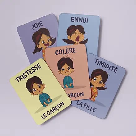Jeu de cartes émotions regroupées Photo de cinq cartes multicolores, regroupées en tas, qui représentent des enfants avec des émotions différentes